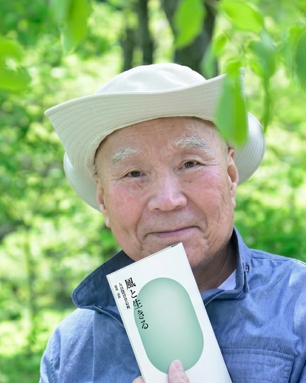 完成した本『風と生きる』を手にする男性